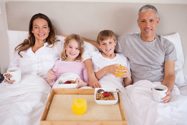 Familia desayunando en un dormitorio