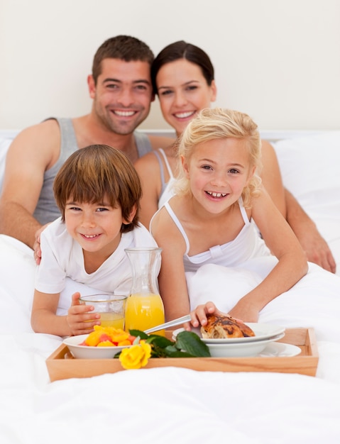 Familia desayunando en el dormitorio