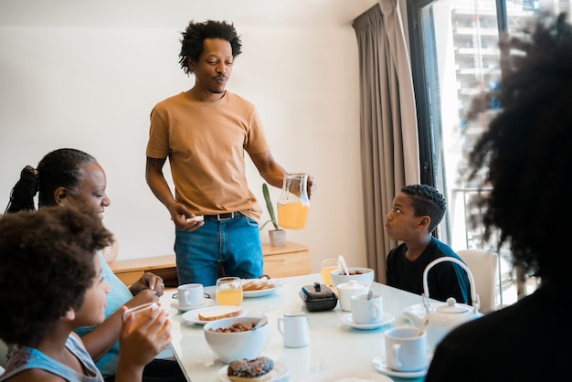 Familia desayunando juntos en casa.