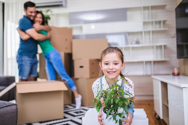 Familia desempacando cajas de cartón en su nuevo hogar.