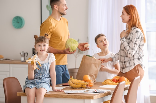 Família desempacotando produtos frescos do mercado na cozinha