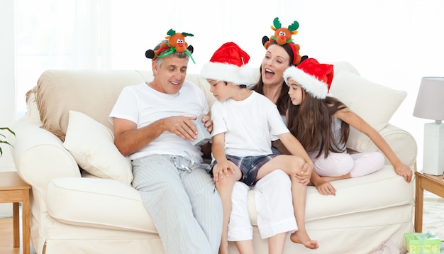 Familia el día de Navidad mirando sus regalos en casa.