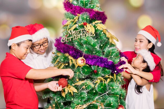 La familia disfruta de la época navideña con la decoración de un árbol