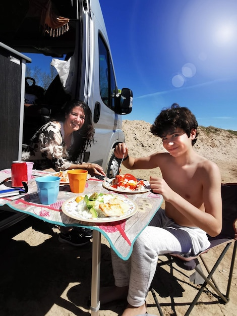 Familia disfrutando de una comida al aire libre en una autocaravana