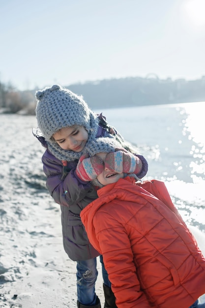 Familia disfrutando del invierno juntos, niños caminando por la playa en invierno