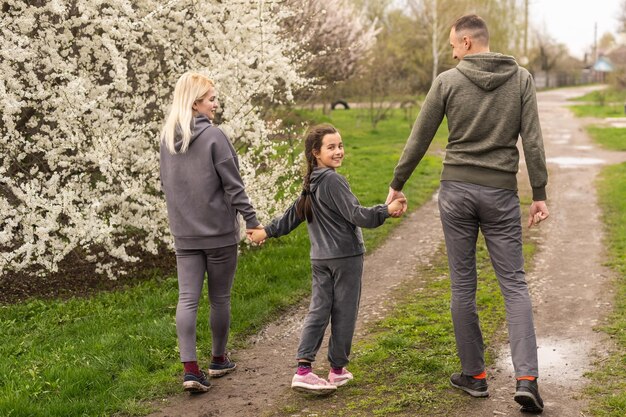 familia divirtiéndose con un árbol en flor en un floreciente jardín de primavera.