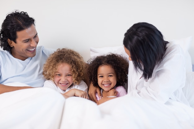 Familia divirtiéndose en el dormitorio