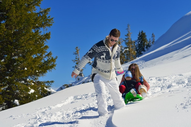 familia divirtiéndose en la nieve fresca en las vacaciones de invierno