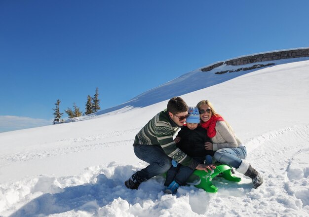 familia divirtiéndose en la nieve fresca en las vacaciones de invierno