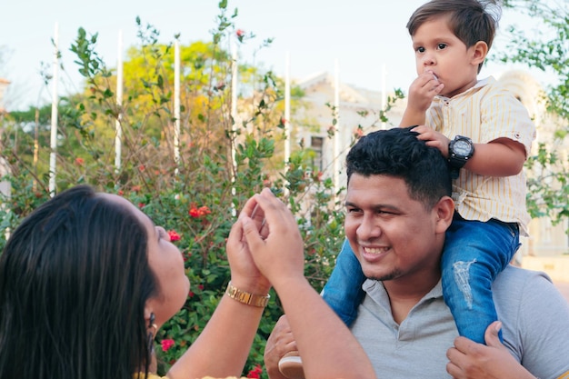 Familia divirtiéndose en el parque con su hijo.