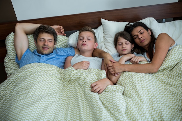 Foto família dormindo juntos no quarto