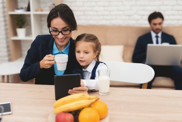 Família dos empresários que sentam-se no sofá em casa.