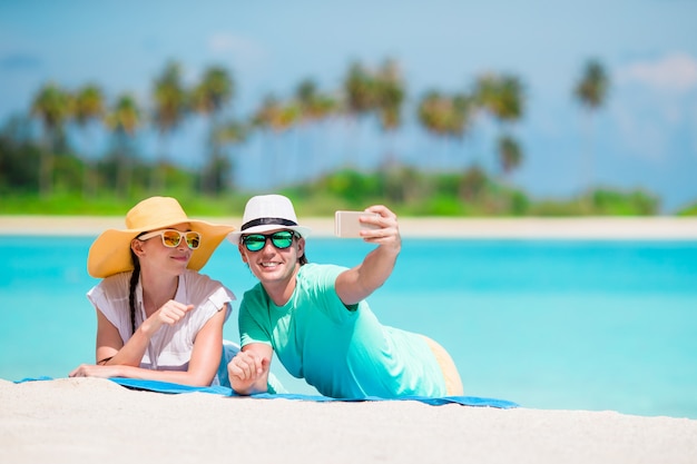 Familia de dos haciendo una selfie con celular en la playa