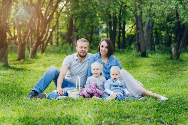 Familia con dos hijos descansa en el jardín de verano.