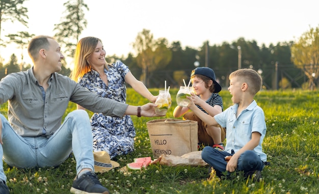 Familia con dos niños picnic de verano en la naturaleza.