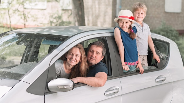 Familia con dos niños sentados en su auto familiar