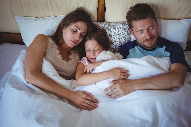 Familia durmiendo en la cama