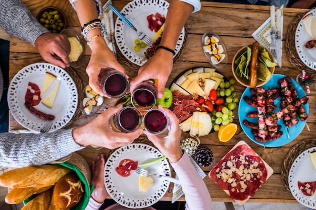 Família e amigos tilintando e tendo fauno em casa durante a ceia de natal