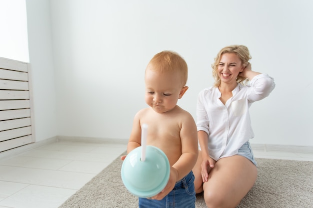 Família e conceito de parentalidade bebê fofo brincando com a mãe no tapete bege