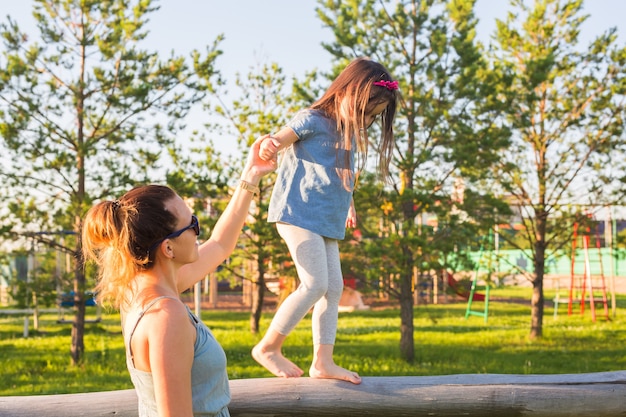 Família e criança conceito mãe e filha caminhando e brincando no parque e desfrutando da