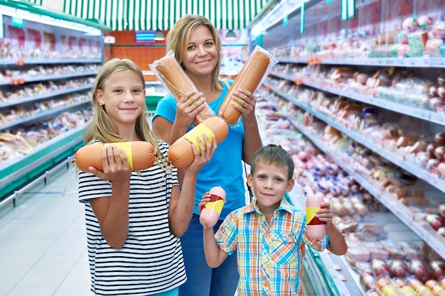 La familia elige salchichas en la tienda