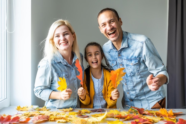 família em casa fazendo artesanato e fazendo foto de folhas na cozinha