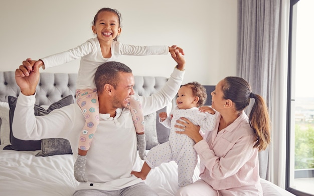 Família em quadrinhos feliz e retrato de quarto enquanto relaxam em casa juntos sorriem para o amor dos pais e férias internacionais no hotel crianças animadas com mãe e pai de férias e sendo brincalhonas na cama