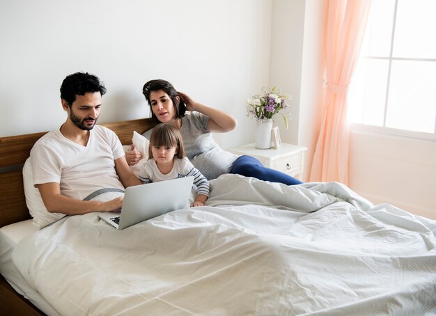 Familia embarazada pasar tiempo juntos usando una computadora portátil