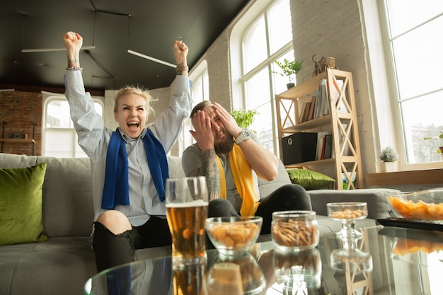 Familia emocionada viendo partido de fútbol en casa Hermosa pareja caucásica