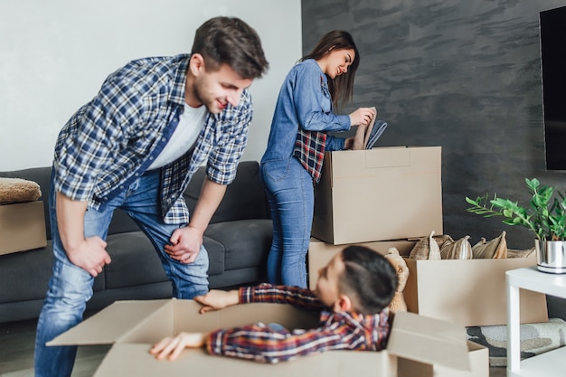 Foto familia empacando cajas de cartón en casa nueva