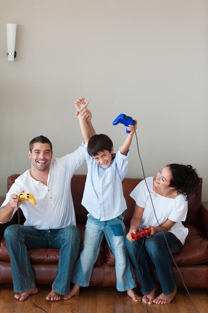 Família encantada jogando videogames na sala de estar