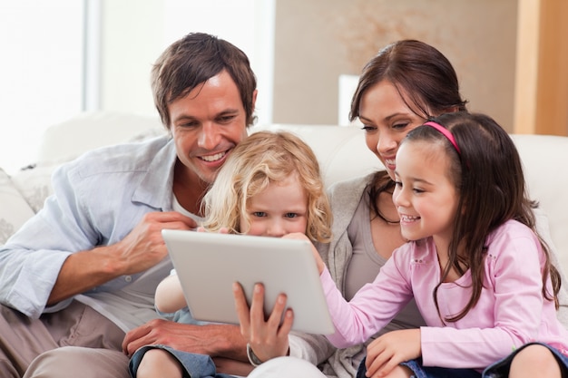 Foto família encantada usando um tablet computador