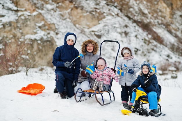 Família escandinava com bandeira da Suécia na paisagem sueca de inverno