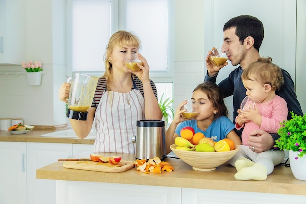 La familia está haciendo batidos en la cocina. Enfoque selectivo.