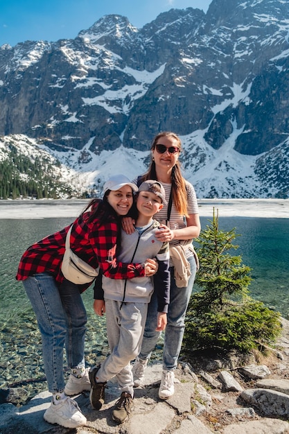 Una familia está de pie en la orilla de un lago Morskie Oko Tatras montañas