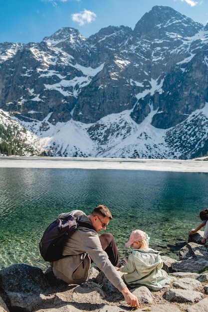 Una familia está sentada en la orilla de un lago Morskie Oko Tatras