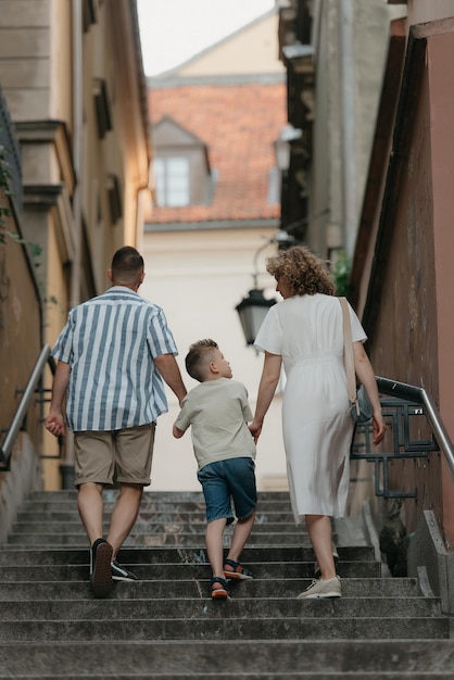 La familia está subiendo escaleras en una vieja ciudad europea