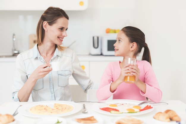 Família estão sentados na cozinha e tomando café da manhã