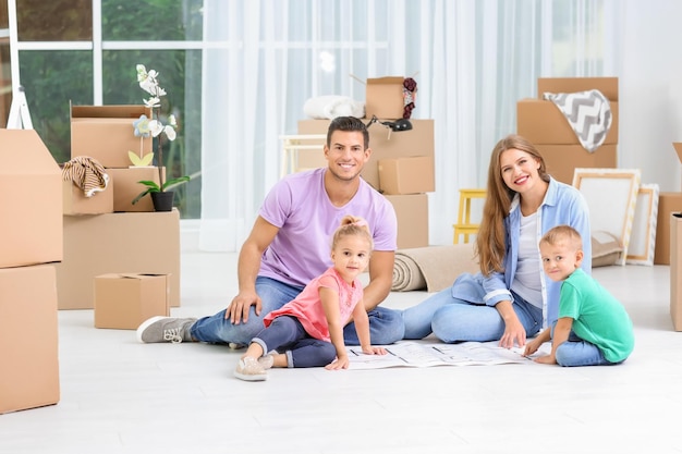 Família estudando o plano de sua nova casa enquanto está sentado no chão