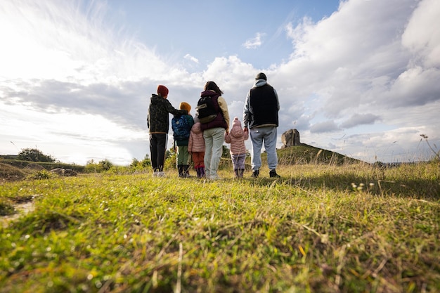 Família explorando a natureza As crianças com os pais se posicionam contra uma grande pedra na colina Pidkamin Ucrânia