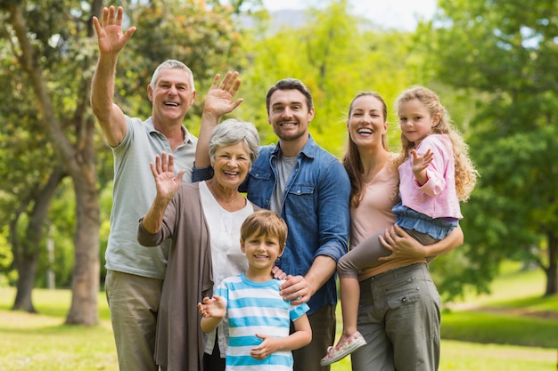 Familia extendida agitando las manos en el parque