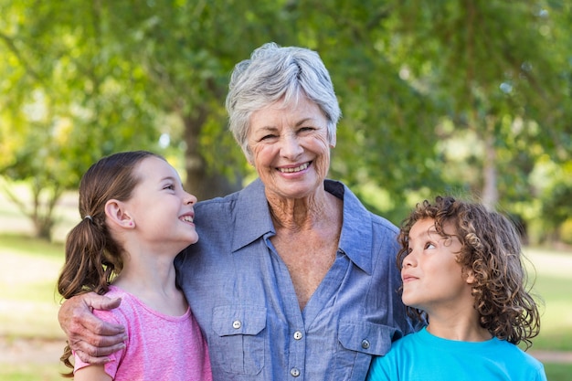 Familia extendida sonriendo y besándose en un parque