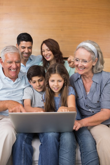 Familia extendida, usar la computadora portátil, en, sofá, en, sala