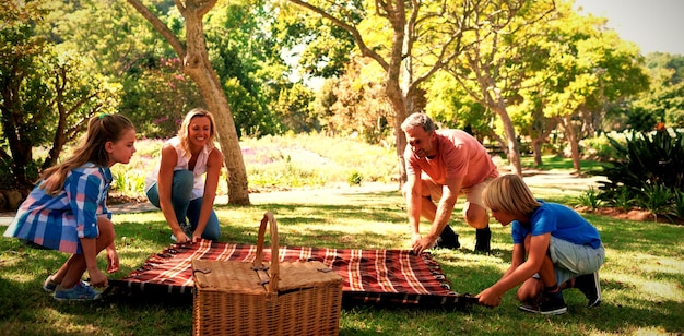 Familia extendiendo la manta de picnic