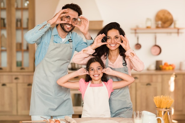 Família fazendo caras com cortadores de biscoitos