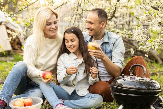 Família fazendo um churrasco em seu jardim.