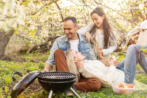 Família fazendo um churrasco em seu jardim.