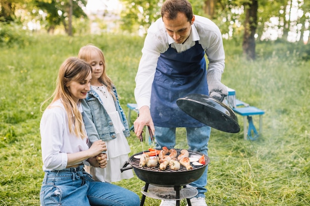 Família fazendo um churrasco na natureza