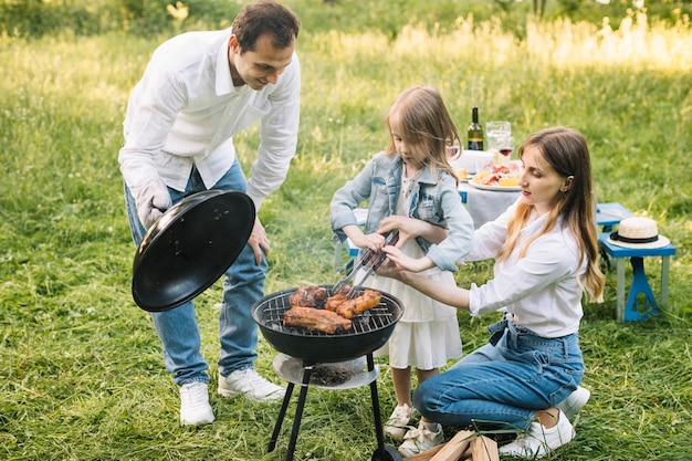 Foto família fazendo um churrasco na natureza