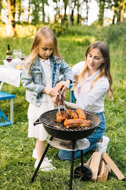 Família fazendo um churrasco na natureza